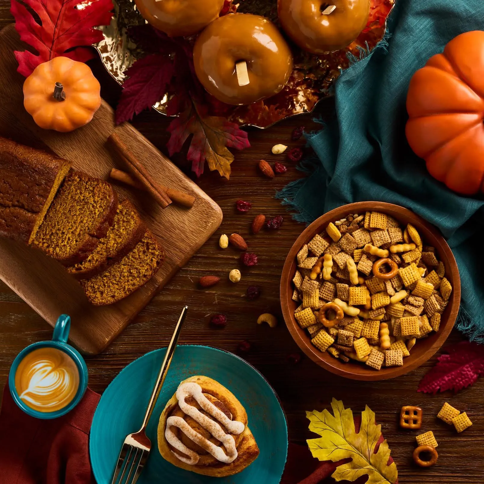 Autumn table spread with pumpkin bread, snack mix, and a latte