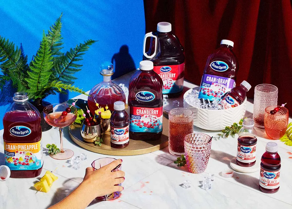 Ocean Spray juice bottles and mocktails on a marble table against a blue wall
