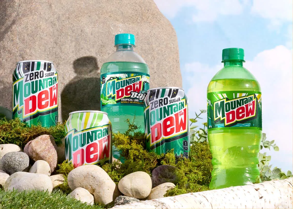 Mountain Dew Zero cans and bottles among rocks and moss under a blue sky