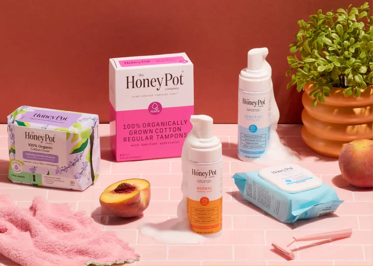Honey Pot personal care products on a pink tiled counter with a peach