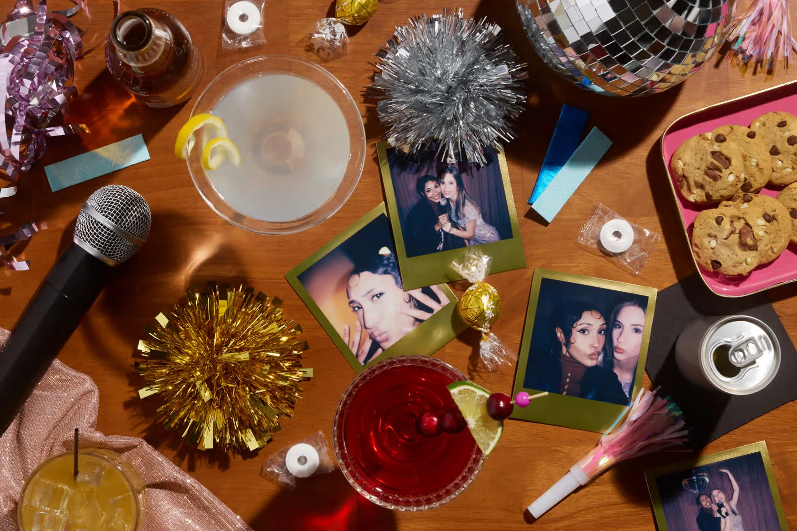 Overhead party table with a microphone, photo prints, and drinks
