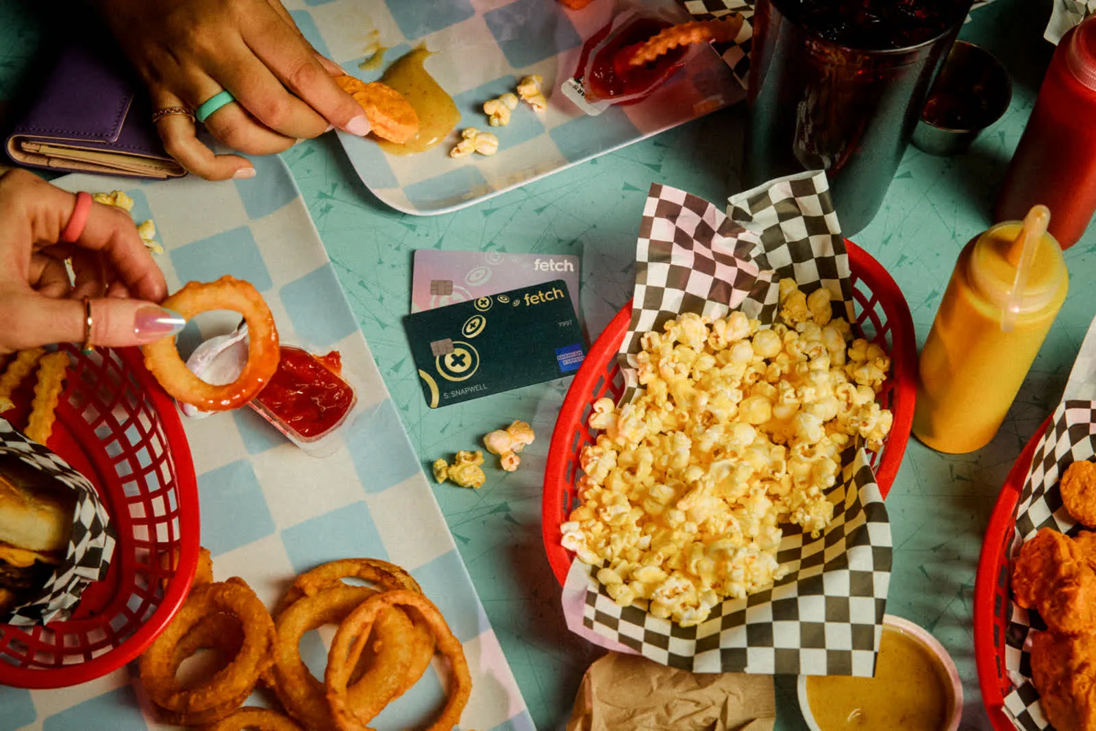 Overhead diner table with popcorn, onion rings, and the Fetch credit card